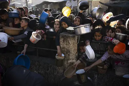 Palestinians line up for a free meal in Rafah, Gaza Strip, on March 12, 2024. (AP Photo/Fatima Shbair, File)