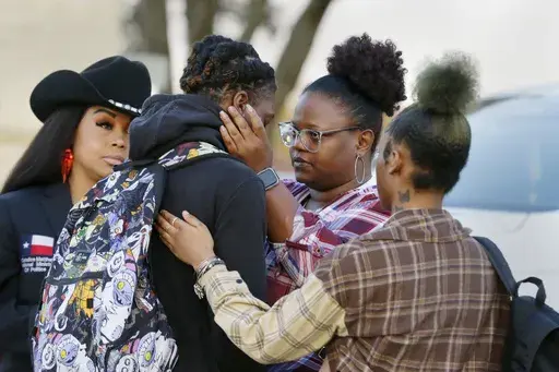 Darryl George, center left, a 17-year-old junior, and his mother Darresha George, center right, share words of encouragement before walking across the street to go into Barbers Hill High School after Darryl served a 5-day in-school suspension for not cutting his hair Monday, Sept. 18, 2023, in Mont Belvieu. George began attending a disciplinary program this week away from his classmates and regular teachers. He said in an interview with The Associated Press that he has felt isolated from and dis