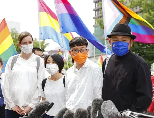 Plaintiffs speak to journalists after a court ruling in Osaka, western Japan Monday, June 20, 2022. The Osaka District Court ruled Monday that the country’s ban on same-sex marriage does not violate the constitution, and rejected demands for compensation by three couples who said their right to free union and equality has been violated. (Kyodo News via AP)