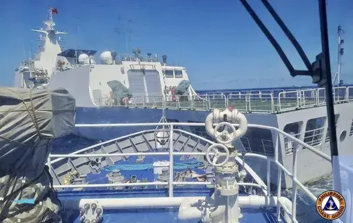 In this photo provided by the Philippine Coast Guard, a Chinese Coastguard ship, front, allegedly blocks the path of a Philippine Coast Guard ship near the Philippine-occupied Second Thomas Shoal, South China Sea during a re-supply mission on Saturday Aug. 5, 2023. The Philippine military condemned on Sunday a Chinese coast guard ship's "excessive and offensive" use of a water cannon to block a Filipino supply boat from delivering new troops, food, water and fuel to a Philippine-occupied shoal i