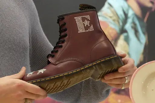A Dr Martens boot inspired by Elton John's famous Pinball Wizard outfit is shown at a promotional event in London, March 20, 2023. Dr. Martens shares plunged more than 30% Tuesday, April 16, 2024 after the trendy British brand forecast that wholesale revenue in the U.S., its largest market, would decline by double-digits compared to that seen a year ago. (AP Photo/Kin Cheung, File)