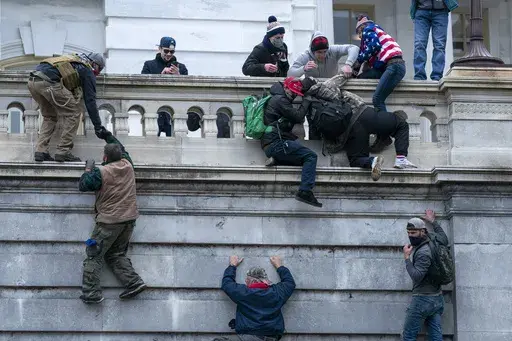 Rioters loyal to President Donald Trump climb the west wall of the the U.S. Capitol, Jan. 6, 2021, in Washington. (AP Photo/Jose Luis Magana, File)