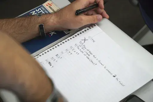 A student checks a classmate's test during an American government class at the University of South Carolina Beaufort in Bluffton, S.C., on Tuesday, Aug. 20, 2024. (AP Photo/Allen G. Breed)