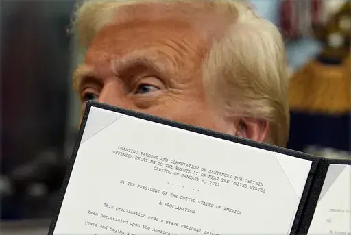 President Donald Trump signs an executive order pardoning about 1,500 defendants charged in the Jan. 6 attack on the U.S. Capitol in the Oval Office of the White House, Monday, Jan. 20, 2025, in Washington. (AP Photo/Evan Vucci)