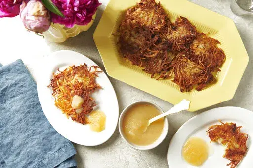 Plates of potato pancakes, or latkes, are displayed in New York in August 2020. Latkes are the food most traditionally associated with Hanukkah. There are all kinds of modern variations using other vegetables and other toppings. (Cheyenne M. Cohen via AP)