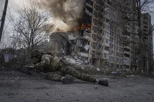 A Ukrainian police officer takes cover in front of a burning building in Avdiivka, Ukraine, Friday, March 17, 2023. The second year of Ukraine’s fight against Russia’s full-scale invasion brought no respite for Ukrainian soldiers or civilians. Associated Press photographers documented the past 12 months of death and destruction, agony and grief — as well as the glimpses of joy — that are staples of life during war. (AP Photo/Evgeniy Maloletka)
