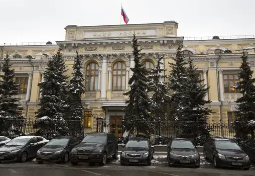 Cars are parked in front of Russia's Central Bank building in Moscow, Russia, Jan. 30, 2015. Prices for Russian credit default swaps — insurance contracts that protect an investor against a default — plunged sharply overnight after Moscow used its precious foreign currency reserves to make a last minute debt payment on Friday April 29, 2022. (AP Photo/Alexander Zemlianichenko, File)