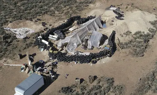 A ramshackle compound is seen in the desert area of Amalia, N.M., on Aug. 10, 2018. Two firearms charges were dismissed Thursday, Sept. 21, 2023, amid preparations for trial against an extended family arrested in a 2018 law enforcement raid on the compound in northern New Mexico and the discovery of a young boy's decomposed body. (AP Photo/Brian Skoloff, File)