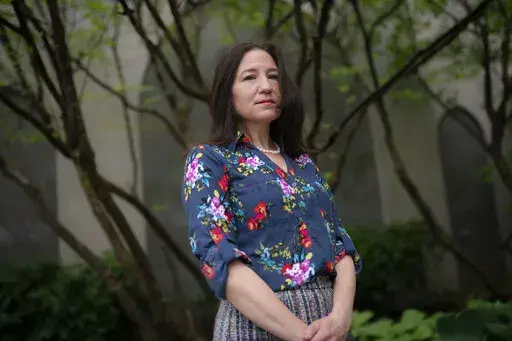 Allyson Jacobs stands for a portrait outside her workplace, Wednesday, May 4, 2022, in New York. For Jacobs, life in her 20s and 30s was about focusing on her career in health care and enjoying the club scene in New York City. It wasn't until she turned 40 that she and her husband started trying to have children. They had a son when she was 42.   (AP Photo/John Minchillo)