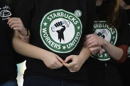 Starbucks employees and supporters link arms during a union election watch party Dec. 9, 2021, in Buffalo, N.Y. The Supreme Court on Friday, Jan. 12, 2024 agreed to hear an appeal from Starbucks in a dispute with the National Labor Relations Board over efforts by workers to unionize at a store in Memphis, Tennessee.(AP Photo/Joshua Bessex, File)