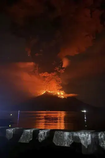 In this photo released by Sitaro Regional Disaster Management Agency (BPBD Sitaro), hot molten lava glows at the crater of Mount Ruang as it erupts in Sanguine Islands, Indonesia, Wednesday, April 17, 2024. Indonesian authorities issued a tsunami alert Wednesday after eruptions at Ruang mountain sent ash thousands of feet high. Officials ordered more than 11,000 people to leave the area. (BPBD Sitaro via AP)