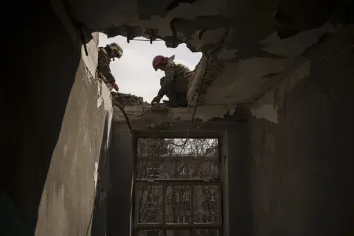 Firefighters work to secure a building previously damaged by a Russian attack in Kharkiv, Ukraine, Saturday, April 9, 2022. (AP Photo/Felipe Dana)
