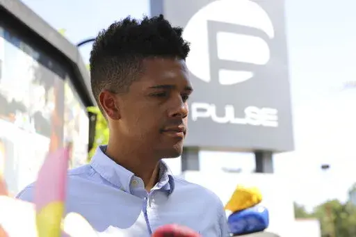 Brandon Wolf, a survivor of the Pulse nightclub shooting and activist, stands outside of the Pulse memorial in Orlando, Fla., on Sept. 9, 2022. After mass shootings, the loss felt by marginalized groups already facing discrimination is compounded. Some public health experts say the risk for post-traumatic stress disorder is greater for the groups, especially when the shootings take place at schools, churches and other vital hubs. (AP Photo/Cody Jackson)