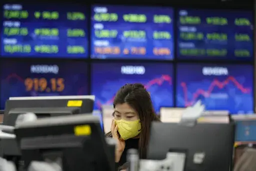 A currency trader watches monitors at the foreign exchange dealing room of the KEB Hana Bank headquarters in Seoul, South Korea, Tuesday, Jan. 25, 2022. Asian shares skidded Tuesday following a volatile day on Wall Street. Inflation-fighting measures from the Federal Reserve and the possibility of conflict between Russia and Ukraine are overhanging markets.(AP Photo/Ahn Young-joon)
