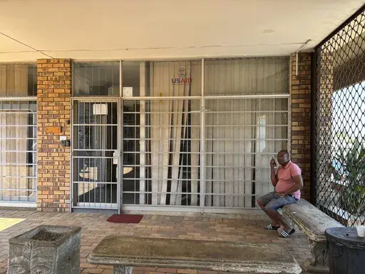 A man sits outside the closed Isizinda Sempilo clinic in the Johannesburg township of Soweto Thursday, Jan. 30, 2025. (AP Photo/Alfonso Nqunjana)