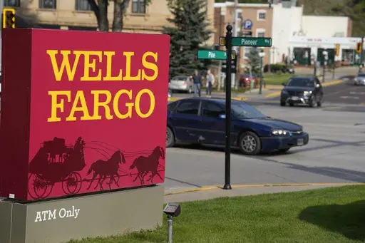 Motorists drive past a sign outside a branch of Wells Fargo bank, Wednesday, Sept. 20, 2023, in Deadwood, S.D. The Biden Administration is easing its restrictions on banking giant Wells Fargo, saying the bank has sufficiently fixed its toxic culture after years of scandals. The news sent Wells Fargo's stock up sharply in afternoon trading as investors speculated that the bank, which has been kept under a tight leash by regulators for years, may be able to start growing again. (AP Photo/David Zal