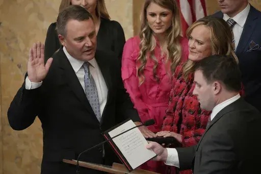 Jolynn McLellan White, second from right, holds the Bible as her husband, Rep. Jason White, R-West, left, recites the oath of office as House Speaker for the Mississippi House of Representatives, delivered to him by Rep. Trey Lamar, R-Senatobia in the Mississippi State Capitol in Jackson, Miss., Tuesday, Jan. 2, 2024. Both chambers of lawmakers were sworn into the new four-year term that began at noon Tuesday. (AP Photo/Rogelio V. Solis)