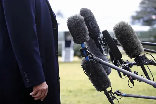 President Donald Trump stands in front of microphones as he speaks to members of the media on the South Lawn of the White House in Washington, Friday, Feb. 7, 2020, before boarding Marine One. Nearly three-quarters of U.S. adults say the news media is increasing political polarization in this country, and just under half say they have little to no trust in the media's ability to report the news fairly and accurately, according to a new survey from The Associated Press-NORC Center for Public Affa