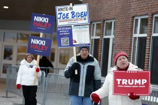 Candidate supporters stand outside a polling location in the presidential primary election, Jan. 23, 2024, in Windham, N.H. Super Tuesday is feeling anything but for many Americans, with the leading presidential contenders already appearing set. A primary season that engages only a fraction of the electorate to choose the presidential candidates is a reminder of how the U.S. election system excludes many voters and differs starkly from that of most other democracies around the world. (AP Photo/M