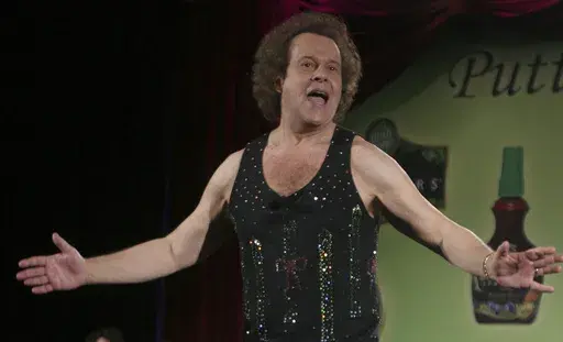 Richard Simmons speaks to the audience before the start of a summer salad fashion show at Grand Central Terminal in New York on June 2, 2006. Simmons, a fitness guru who urged the overweight to exercise and eat better, died Saturday, July 13, 2024, at the age of 76. (AP Photo/Tina Fineberg, File)