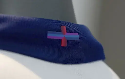 A view of Nike's designed St George's Cross on the back of the collar of the new England shirt at St. George's Park, Burton upon Trent, England, Friday March 22, 2024. England's new men's soccer team shirt is out and it's causing a bit of a stir. And it's not just the price that's vexing some. The decision by Nike to change the color of the St. George’s Cross on the new shirt from the traditional red and white has even prompted the prime minister and the man who is favored to succeed him to ma