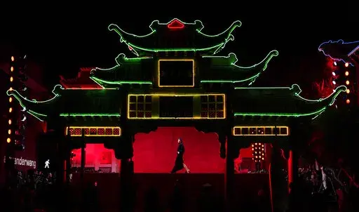 A model is framed in the East Gate at Old Chinatown Plaza as she walks the runway at fashion designer Alexander Wang's "Fortune City" runway show and party celebrating Asian-American culture, Tuesday, April 19, 2022, in Los Angeles. (AP Photo/Chris Pizzello)