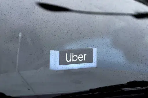An Uber sign is displayed inside a car, May 15, 2020, in Chicago. The Biden administration will enact a new labor rule Tuesday, Jan. 9, 2024, that aims to prevent the misclassification of workers as “independent contractors,” a step that could bolster both legal protections and compensation for many in the U.S. workforce. (AP Photo/Nam Y. Huh, File)