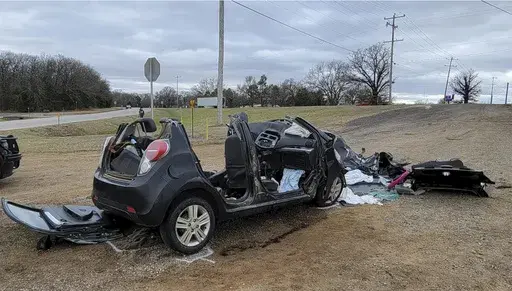 In this image provided by KFOR-TV, a heavily damaged vehicle is seen off a road in Tishomingo, Okla., following a two-vehicle collision in which six teenage students were killed, March 22, 2022. The crash has the National Transportation Safety Board urging parents to warn teenagers about the risk of driving after using marijuana. (NewsNation KFOR via AP File)