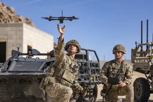 In this photo from the Defense Visual Information Distribution Service, British soldiers launch a drone during Project Convergence exercises at Fort Irwin, Calif., on Nov. 4, 2022. With tensions high over Taiwan, U.S. and Chinese military planners are readying themselves for a new kind of war where battleships, fighter jets and amphibious landings cede prevalence to squadrons of AI-enabled air and sea drones. (DVIDS via AP)