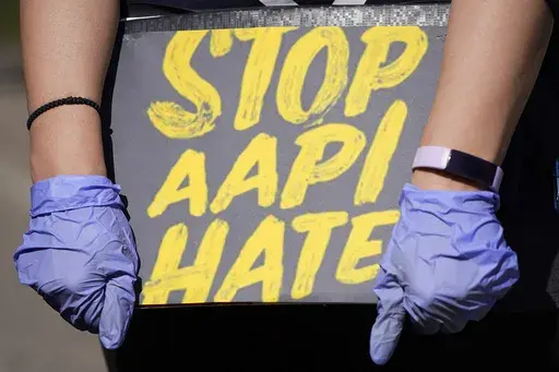 A person holds a sign and attends a rally to support stop AAPI (Asian Americans and Pacific Islanders) hate at the Logan Square Monument in Chicago, on March 20, 2021. Despite ongoing efforts to combat anti-Asian racism that arose after the pandemic, a third of Asian Americans and Pacific Islanders say they have experienced an act of abuse based on their race or ethnicity in the last year. (AP Photo/Nam Y. Huh, File)