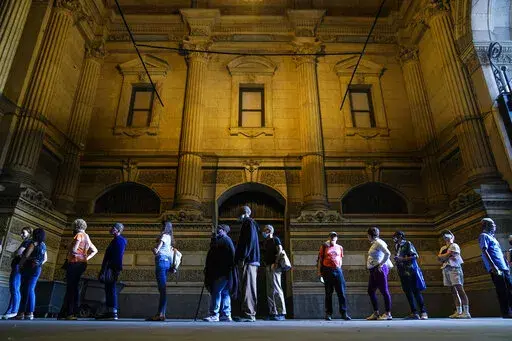 Voters wait in line to make corrections to their ballots for the midterm elections at City Hall in Philadelphia, Monday, Nov. 7, 2022. According to data from AP VoteCast, voters with no religious affiliation supported Democratic candidates and abortion rights by staggering percentages in the 2022 midterm elections. (AP Photo/Matt Rourke)