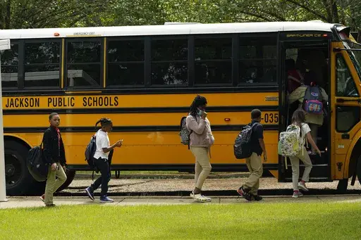 Spann Elementary School students board a school bus following a full day of in-school learning, Sept. 6, 2022, in Jackson, Miss. After the COVID-19 pandemic disrupted schools around the country and led to more children missing classes, the number of students who were chronically absent in Mississippi declined during the most recent school year, according to data released, Tuesday, Sept. 26, 2023, by the state's education department. (AP Photo/Rogelio V. Solis, File)