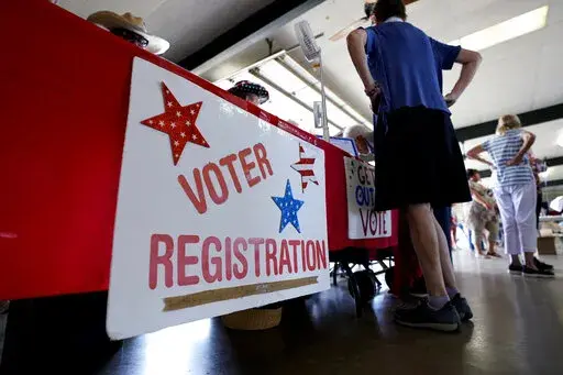 A voter registration table is seen at a political event for Texas gubernatorial candidate Beto O'Rourke, Wednesday, Aug. 17, 2022, in Fredericksburg, Texas. On the brink of November's midterm elections, both full-time election workers in rural Gillespie County suddenly and stunningly quit this month with less than 70 days before voters start casting ballots. (AP Photo/Eric Gay)