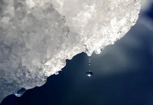 A drop of water falls off an iceberg melting in the Nuup Kangerlua Fjord near Nuuk in southwestern Greenland, Tuesday, Aug. 1, 2017. Earth’s poles are undergoing simultaneous freakish extreme heat with parts of Antarctica more than 70 degrees (40 degrees Celsius) warmer than average and areas of the Arctic more than 50 degrees (30 degrees Celsius) warmer than average. (AP Photo/David Goldman, File)