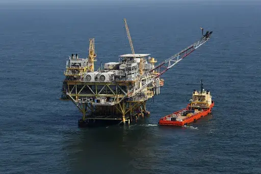 A rig and supply vessel are viewed in the Gulf of Mexico off the cost of Louisiana, April 10, 2011. A sale of federal Gulf of Mexico oil and gas leases that had been scheduled for Wednesday, Nov. 8, 2023, was officially postponed by the Biden administration on Thursday, Nov. 2. (AP Photo/Gerald Herbert, File)