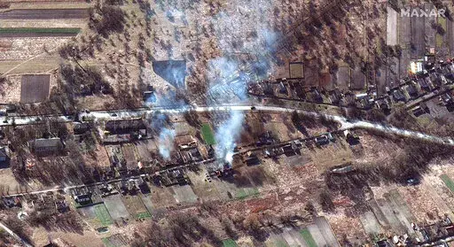 This satellite image provided by Maxar Technologies shows part of military convoy and burning homes northwest of Invankiv, Ukraine Monday, Feb. 28, 2022. (Satellite image ©2022 Maxar Technologies via AP)