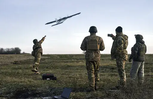 Ukrainian soldiers launch a drone at Russian positions near Bakhmut, Donetsk region, Ukraine, Thursday, Dec. 15, 2022. (AP Photo/LIBKOS)
