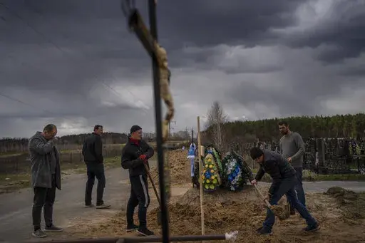 Anatoliy Morykin, 45, left, mourns the death of his mother Valentyna Morykina, 82, who died in a retirement home due to poor living conditions during the Russian invasion in Bucha, on the outskirts of Kyiv, Ukraine, Tuesday, April 12, 2022. (AP Photo/Rodrigo Abd)