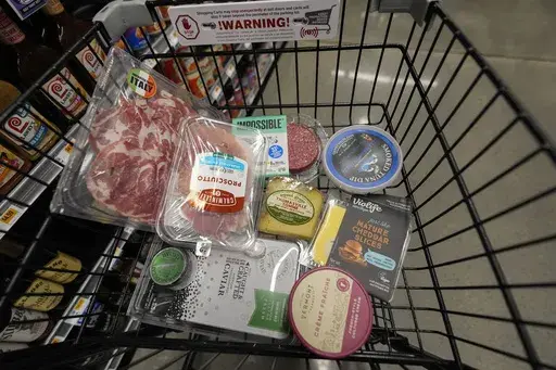 An assortment of vegan, organic, locally sourced, and wild caught food products all using plastic packaging, sit in a shopping cart at a grocery store in New Orleans, Wednesday, April 17, 2024. People are increasingly breathing, eating and drinking tiny particles of plastic, however, there are simple things people can do at the grocery store if they want to use less plastic. (AP Photo/Gerald Herbert)