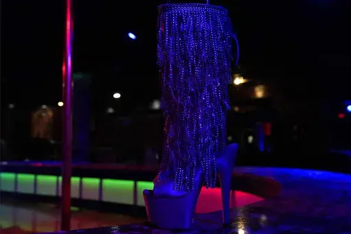 An exotic dancer's shoe on stage at Scores Gentlemen's Club, Jan. 27, 2021, in Tampa, Fla. A stripper and the strip club where she worked have sued Florida’s attorney general to stop enforcement of a new state law took effect on Monday, July 1, 2024, prohibiting adult entertainment businesses from employing people who are under age 21, claiming it violates their First Amendment rights. (AP Photo/Chris O'Meara, File)