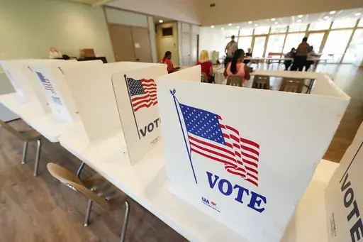 Empty poll kiosks await voters at the Mississippi Second Congressional District Primary election precinct June 7, 2022, in Jackson, Miss. Prosecutors are trying to stop the menacing of election workers as violent and graphic threats are deluging workers even in normally quiet periods between elections. (AP Photo/Rogelio V. Solis, File)
