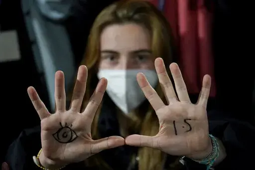 A youngster, with an eye drawn on her hand to show she is watching and 1.5 for countries to keep warming below 1.5 degrees Celsius, takes part in a Fridays for Future climate protest inside a plenary corridor at the SEC (Scottish Event Campus) venue for the COP26 U.N. Climate Summit, in Glasgow, Scotland, Nov. 10, 2021. The idea of tinkering with the air to cool Earth's ever-warming climate seems to be gaining momentum. Two new high-powered panels have started to look at the ethics and governing