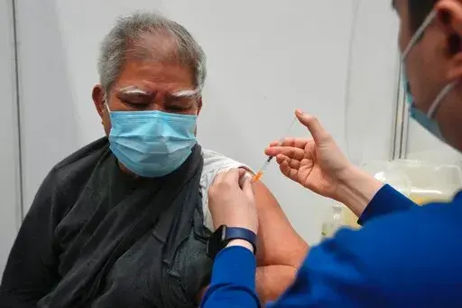 Hui Ngai-seng, 75, receives his first dose of China's Sinovac COVID-19 coronavirus vaccine at a community vaccination center in Hong Kong, Friday, Feb. 25, 2022. (AP Photo/Kin Cheung)
