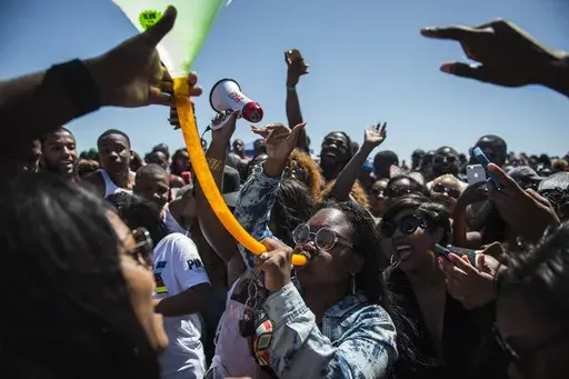 A crowd of party-goers cheer for a woman drinking from a beer bong during Orange Crush on Tybee Island, Ga., April 16, 2016. Thousands of Black college students expected this weekend for an annual spring bash at Georgia's largest public beach shouldn't expect a warm welcome. Tybee Island's city leaders are bringing in dozens of extra police officers and using barricades to block parking lots and residential streets during Orange Crush, a sprawling beach party begun three decades ago. (Josh Galem