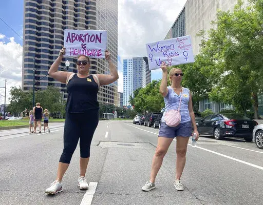 Protesters wave signs and demonstrate in support of abortion access in front of a New Orleans courthouse Friday July 8, 2022. Inside the courthouse a judge was hearing arguments on the state's trigger law designed to outlaw almost all abortions. (AP Photo/Rebecca Santana)