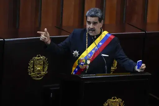 Venezuelan President Nicolas Maduro holds a small copy of his nation's constitution during ceremony marking the start of the judicial year at the Supreme Court in Caracas, Venezuela, Jan. 31, 2024. A secret memo obtained by The Associated Press details a covert operation by the U.S. Drug Enforcement Administration that sent undercover operatives into Venezuela to record and build drug-trafficking cases against the country’s leadership including Venezuelan President Nicolás Maduro. (AP Photo/A