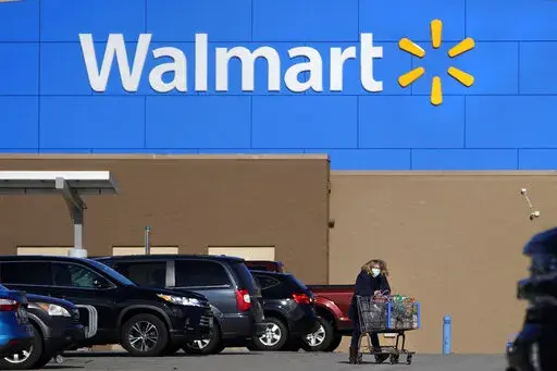 A woman wheels a cart with her purchases out of a Walmart, on Nov. 18, 2020, in Derry, N.H.   Walmart Inc.  on Tuesday, Aug. 16, 2022,  reported fiscal second-quarter net income of $5.15 billion.
The Bentonville, Arkansas-based company said it had profit of $1.88 per share. Earnings, adjusted for non-recurring gains, were $1.77 per share.  (AP Photo/Charles Krupa, File)