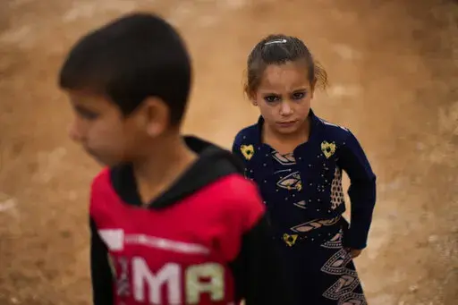 Syrian children wait for donated toys and food to be distributed in a refugee camp for displaced people supported by the Turkish Red Crescent in Sarmada, north of Idlib city, Syria, Thursday, Nov. 25, 2021. (AP Photo/Francisco Seco)