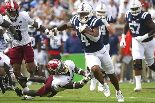 Mississippi running back Quinshon Judkins (4) runs the ball past Troy safety Craig Slocum Jr. (4) during the first half an NCAA college football game in Oxford, Miss., Saturday, Sept. 3, 2022. (AP Photo/Thomas Graning)